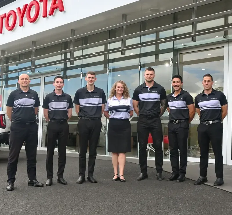 Pacific Toyota team standing out the front of the dealership wearing grey and black custom corporate uniforms by Uniform Link