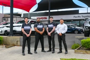 Pacific Toyota team standing out the front of the dealership wearing custom uniforms by Uniform Link
